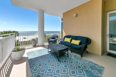 a patio with a couch and a table on a balcony at Sterling Beach #301 in Panama City Beach