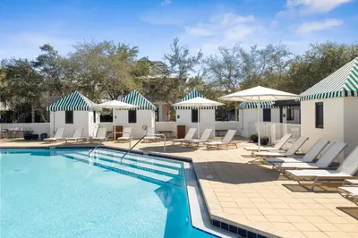 a swimming pool with lounge chairs and umbrellas at Ocean`s Six by 30A Escapes in Rosemary Beach