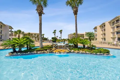 a large pool with palm trees in a resort at HP 315 Condo by 30A Escapes in Rosemary Beach