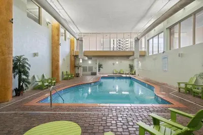 a large swimming pool in a building with green chairs at Shores Of Panama #1509 in Panama City Beach