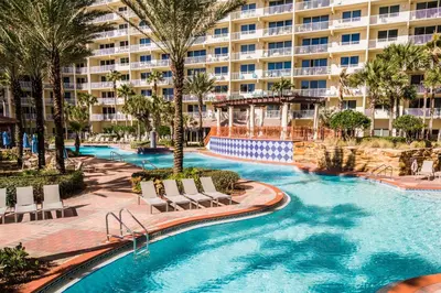 a resort swimming pool with chairs and a building at Shores of Panama #1230 by Nautical Properties in Panama City Beach