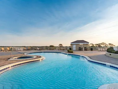a pool at a resort with blue water at Grand Panama Beach Resort - The Grand II #1108 in Panama City Beach