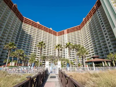 a large building with palm trees in front of it at Shores of Panama #1129 in Panama City Beach