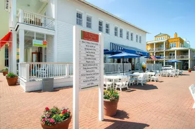 a sign in front of a building with tables and chairs at Beachside Villas 814 in Santa Rosa Beach