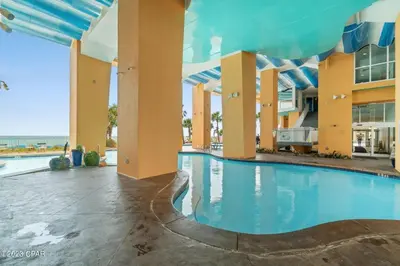 a pool at the resort with the ocean in the background at Beachfront Oasis at Splash Resort and Condos in Panama City Beach