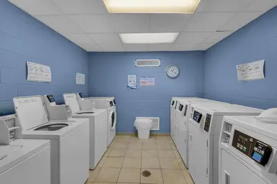 a blue room with washing machines and a toilet at Sunbird 906W in Panama City Beach