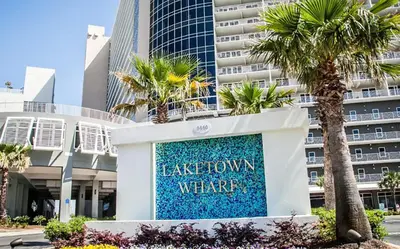 a sign in front of a building with palm trees at Laketown Wharf 2117 'High Tide' in Panama City Beach