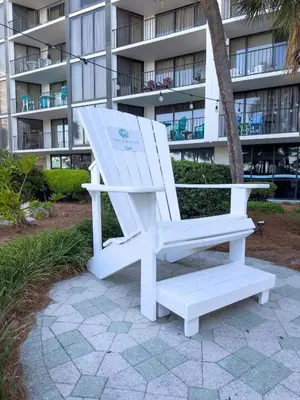 a white chair sitting in front of a building at Edgewater 2-0409 'Paradise City' in Panama City Beach