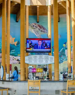 a bar with a television on the wall of a seafood restaurant at Edgewater W208 Beach Bungalow Bliss in Panama City Beach