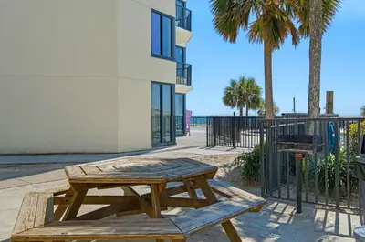 a wooden picnic table in front of a building at Sunbird 807E in Panama City Beach