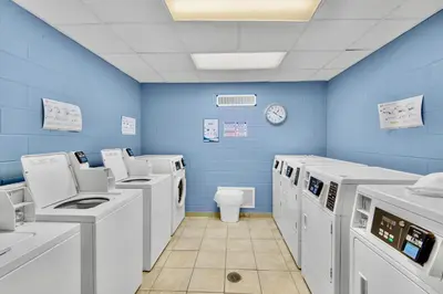 a blue room with washing machines and a toilet at Sunbird Resort Ground Floor Gem with Ocean Views! Free Beach Chairs and Umbrella! by Dolce Vita Getaways PCB in Panama City Beach