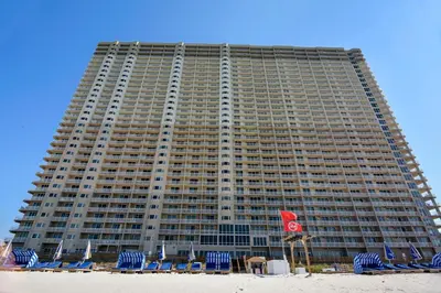 a large building with chairs and a beach at Tidewater Beach Resort #1110 by Book That Condo in Panama City Beach