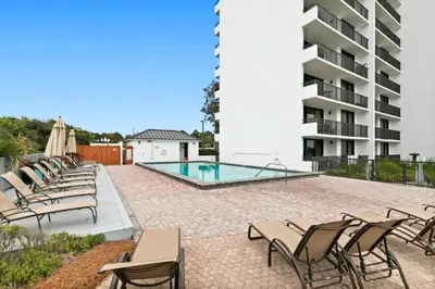 a patio with chairs and a swimming pool at One Seagrove Place 0601 in Santa Rosa Beach
