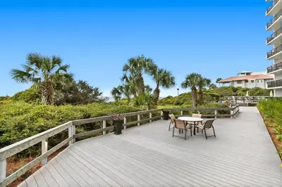a boardwalk with a table and chairs on it at One Seagrove Place 1007 in Santa Rosa Beach