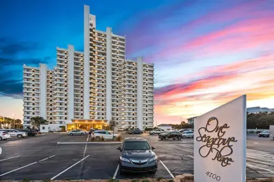 a parking lot with a car parked in front of a large building at One Seagrove Place 0807 in Santa Rosa Beach