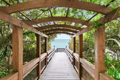 a wooden bridge over a boardwalk leading to the ocean at One Seagrove Place 1408 in Santa Rosa Beach