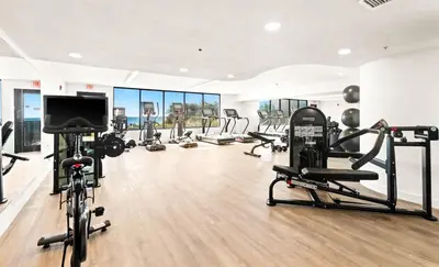 a gym with several tread machines and a flat screen tv at One Seagrove Place 1106 in Santa Rosa Beach