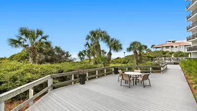 a balcony with a table and chairs on a boardwalk at One Seagrove Place 0205 in Santa Rosa Beach