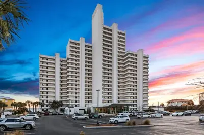 a large white building with cars parked in a parking lot at One Seagrove Place 1508 in Santa Rosa Beach