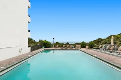 a swimming pool with chairs and tables at One Seagrove Place 1706 in Santa Rosa Beach