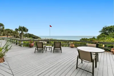a wooden deck with chairs and tables and the ocean at One Seagrove Place 1505 in Santa Rosa Beach