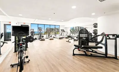 a gym with several tread machines and a flat screen tv at One Seagrove Place 0305 in Santa Rosa Beach