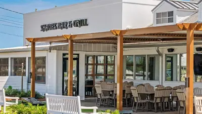a restaurant with chairs in front of a building at Villas Bahama West 106 in Panama City Beach