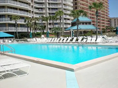 a swimming pool with lounge chairs and a large building at Dunes of Panama 205D in Panama City Beach