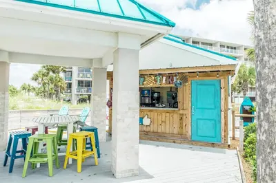 a patio with a table and chairs and a building at Dunes of Panama 205D in Panama City Beach