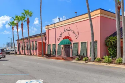 a pink building on the side of a street with palm trees at Watercrest 1502 - Walkin’ on Sunshine in Panama City Beach