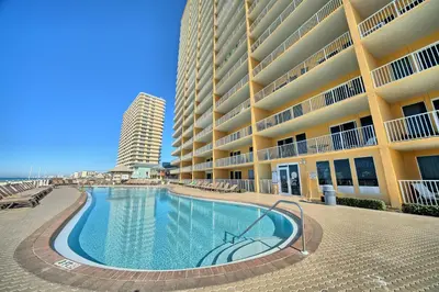 a swimming pool in front of a large building at Treasure Island 1911 in Panama City Beach