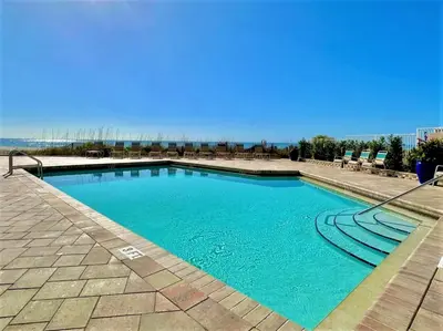 a swimming pool with blue water on a patio at Pelican Walk 902 in Panama City Beach