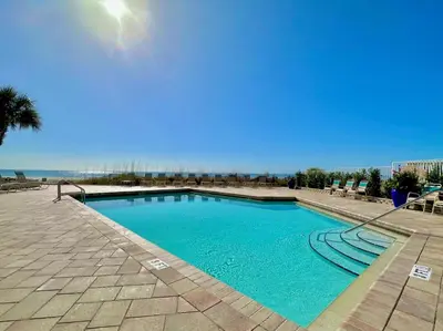 a swimming pool with blue water in a resort at Pelican Walk 110 in Panama City Beach