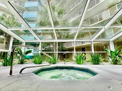 a large building with a hot tub in a courtyard at Pelican Walk 710 in Panama City Beach