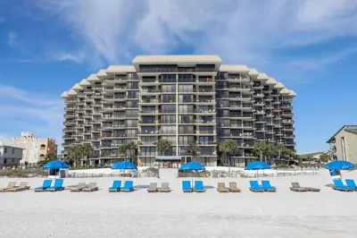 a large building on the beach with chairs and umbrellas at Pelican Walk 107 in Panama City Beach