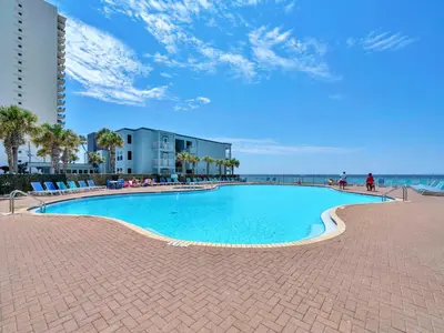 a large swimming pool next to the beach at Tidewater 1916 in Panama City Beach