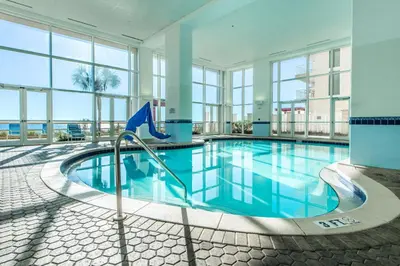 a swimming pool in a building with windows at Majestic Beach Towers 2-404 in Panama City Beach
