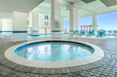 a pool in the middle of a building with chairs at Majestic Beach Towers 2-404 in Panama City Beach