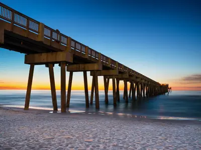 a wooden pier on the beach at sunset at PC Beach Retreat A in Panama City Beach