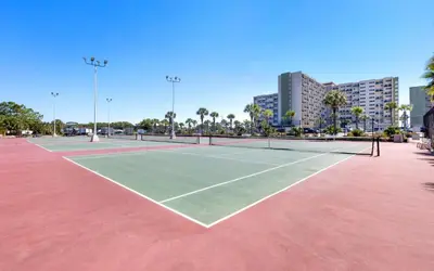 a tennis court in a city with buildings at Ocean Breezes by Oversee 30A in Carillon Beach