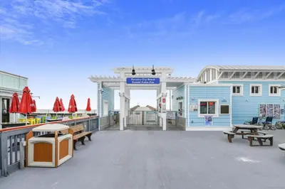 a large deck with benches and a blue building at 2340 Grand Oaks Ln home in Panama City Beach