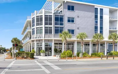an office building with palm trees in front of it at Instant Gratification by Oversee 30A in Santa Rosa Beach