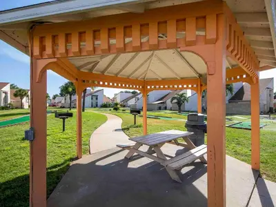 a wooden pavilion with a picnic table in a park at Horizon South #76E in Panama City Beach