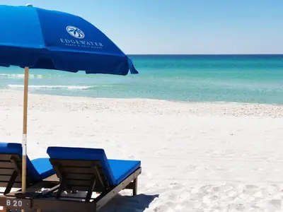 two chairs and an umbrella on a beach at Edgewater Villa #2008 Gulf Breeze Getaway in Panama City Beach