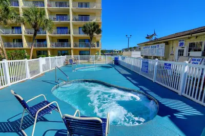 a hot tub with two chairs and a hotel at Summit Beach Resort #1202 in Panama City Beach