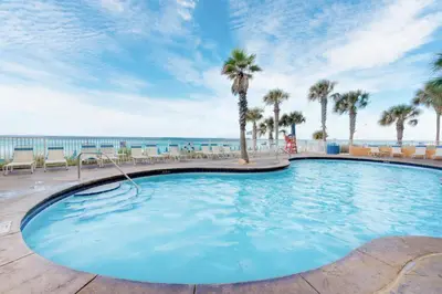 a large swimming pool with palm trees and the ocean at Splash 507E in Panama City Beach