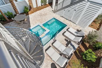 an overhead view of a swimming pool with chairs and a table at 30A Sunrise 6 Bedroom in Santa Rosa Beach