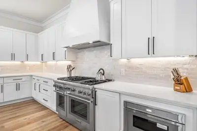 a kitchen with white cabinets and a stove at 30A Sunset 6 Bedroom in Santa Rosa Beach