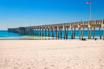 a beach with a pier in the water at Sand Castles West B28 (1/1) in Panama City Beach