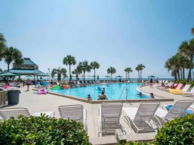 a pool with chairs and people in the water at Dunes of Panama #B203 in Panama City Beach
